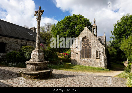 Croix de Pierre en face de la petite église dans le village médiéval de Locronan en Bretagne, France Finistère. Banque D'Images