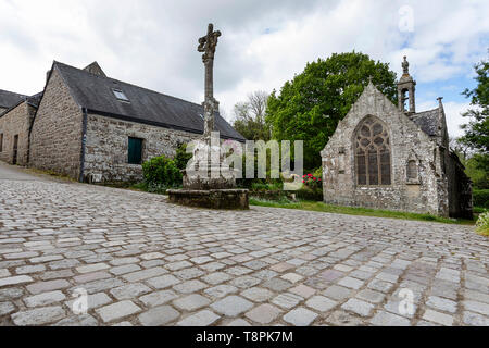 Croix de Pierre en face de la petite église dans le village médiéval de Locronan en Bretagne, France Finistère. Banque D'Images