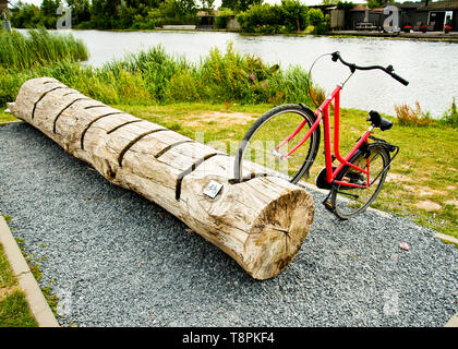 vélo garés dans un stand de vélo en bois inhabituel, juste à côté de la piste cyclable de la rive du canal. Banque D'Images