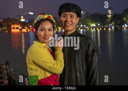 Vietnam, Hanoi, la vieille ville, le pont de Huc sur le lac Hoan Kiem (lac de l'Epée restituée) et la pagode Ngoc Son (temple de la montagne de jade), couple en costume traditionnel vietnamien Banque D'Images