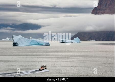 Le Groenland, côte ouest, la baie de Baffin, bateau de pêche et des icebergs dans le fjord Uummannaq Banque D'Images