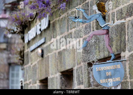Cute metal figure faisant des bulles sur l'enseigne d'une boutique sur préservé village médiéval de Locronan en Bretagne, Francestone maisons. Finistère Banque D'Images