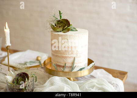 Gâteau de mariage blanc élégant avec des fleurs et plantes grasses en style Boho. Gâteau de mariage rustique Banque D'Images