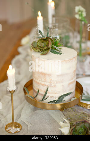 Gâteau de mariage blanc élégant avec des fleurs et plantes grasses en style Boho. Gâteau de mariage rustique Banque D'Images