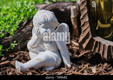 Petit Ange de pierre blanche sur un cimetière dans le soleil, Close up image en couleur Banque D'Images