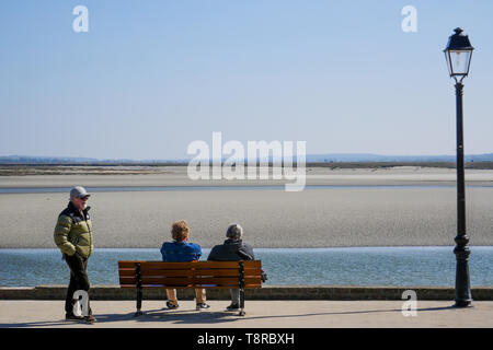 Couple assis sur un banc face à la marin à marée basse, le Crotois, Baie de Somme, Hauts-de-France, France Banque D'Images