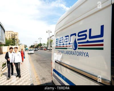 Bakou, Azeirbaijan - 1 mai 2019 : Groupe de jeunes garçons autour de van avec Azersu logotype. Open Joint Stock Company est en charge de la politique et de la stratégie pour l'approvisionnement en eau et d'assainissement en Azerbaïdjan Banque D'Images