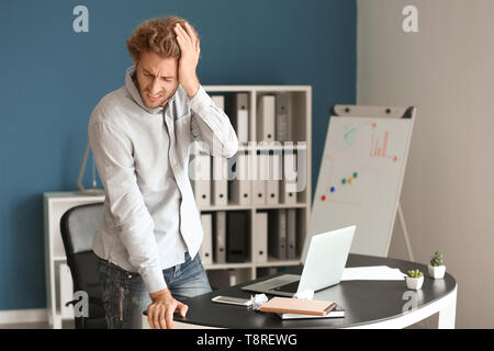 Beau stressed businessman souffrant de maux in office Banque D'Images