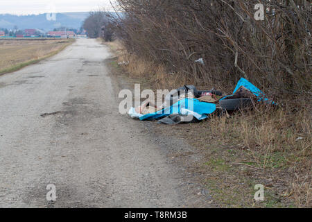 Embout en faisant voler ordures une mise à par dans un chemin de campagne. Tas de déchets ménagers déposés illégalement à gauche sur un côté du chariot-road. Voler en bordure de la TIPP Banque D'Images