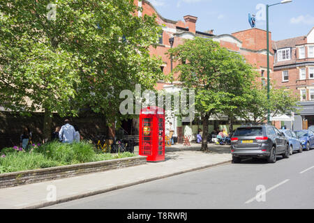 Un converti Sir Giles Gilbert Scott K6 téléphone fort, maintenant utilisé pour stocker un défibrillateur, en face de l'Église, cinéma Olympique, Barnes, London, SW13, UK Banque D'Images