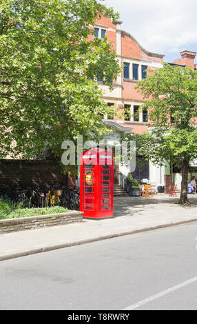 Un converti Sir Giles Gilbert Scott K6 téléphone fort, maintenant utilisé pour stocker un défibrillateur, en face de l'Église, cinéma Olympique, Barnes, London, SW13, UK Banque D'Images