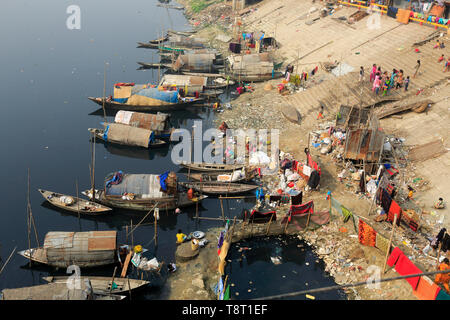 Femmes gitanes et les filles, qui vivent sur les bateaux, faire tout le nettoyage domestique dans le pitch-dark, l'eau polluée de la rivière Turag à Tongi à Gazipur. Banque D'Images