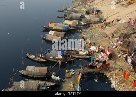 Femmes gitanes et les filles, qui vivent sur les bateaux, faire tout le nettoyage domestique dans le pitch-dark, l'eau polluée de la rivière Turag à Tongi à Gazipur. Banque D'Images