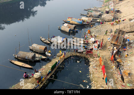 Femmes gitanes et les filles, qui vivent sur les bateaux, faire tout le nettoyage domestique dans le pitch-dark, l'eau polluée de la rivière Turag à Tongi à Gazipur. Banque D'Images