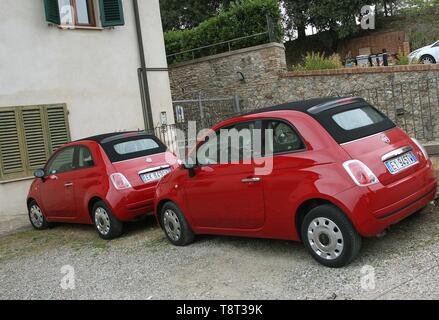 Deux Fiat 500 rouge identiques stationné sur une allée de maison dans la ville perchée de San Gimignano en Toscane Italie Europe Europe 2018 Banque D'Images