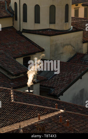 Ville italienne détail dans Bergamo Alta, une vapeur blanche s'échappe d'une cheminée d'une maison avec le toit rouge Banque D'Images