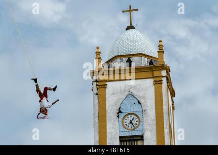 Un Volador se produit devant l'église de l'Assomption à Papantla, Veracruz, Mexique. La Danza de los Voladores est une cérémonie totonaque impliquant cinq participants qui montent un pôle de trente mètres. Quatre de ces attaches des cordes autour de leur taille et le vent l'autre extrémité autour de la partie supérieure du poteau afin de descendre au sol. Le cinquième participant reste au sommet du poteau, la lecture d'une flûte et un petit tambour. La cérémonie a été inscrit comme un chef-d'oeuvre du patrimoine oral et immatériel de l'humanité par l'UNESCO. Banque D'Images