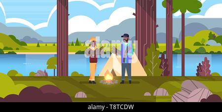 Couple de touristes randonneurs holding bois african american man woman l'organisation de feu près de la tente de camping camp randonnée concept paysage nature river Illustration de Vecteur