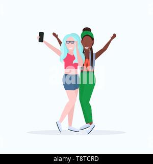 Mélanger la race femmes prenant des photos sur l'appareil photo du smartphone selfies deux personnages féminins se tenant ensemble posant sur fond blanc télévision pleine longueur Illustration de Vecteur