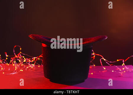 Chapeau de magicien noir sur fond de couleur foncée. Banque D'Images