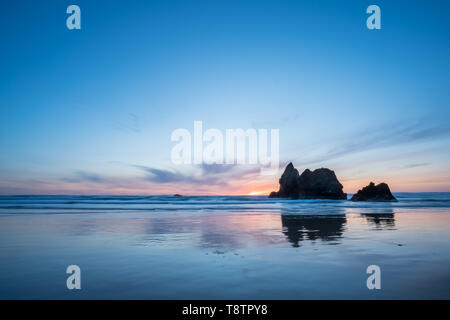 Photo de paysage de coucher du soleil dans l'Oregon Beach avec de grosses roches au large Banque D'Images