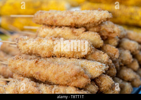 Ailes de poulet frit avec des brochettes en pâte pour vendre au marché de l'alimentation de rue, la Thaïlande, Close up Banque D'Images