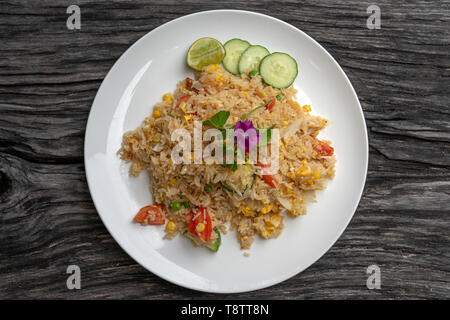 Le riz frit aux crevettes et légumes dans une assiette blanche sur une vieille table en bois, Close up . Thai Food , la cuisine thaïlandaise. Riz frit avec des fruits de mer dans le res Banque D'Images