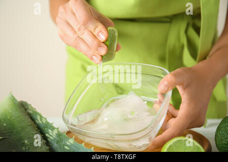 Woman making aloe vera gel à table, gros plan Banque D'Images