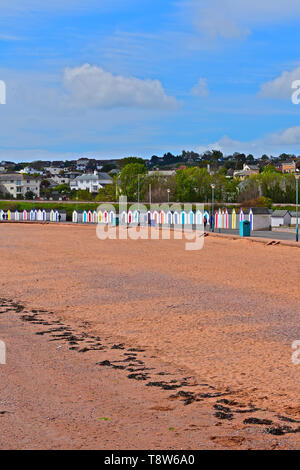 En milieu de matinée à vue à marée basse près de Goodrington Sands Paignton. Cabines de plage multicolores, faire une toile colorée à la plage de sable rouge. Banque D'Images