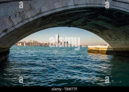 Pont de pierre traversant l'un des nombreux canaux de la ville, le Grand Canal et di San Giorgio Maggiore dans la distance Banque D'Images