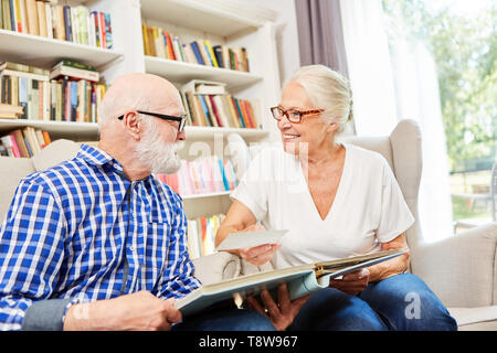 Heureux couple de personnes âgées est à la recherche d'un album photo de la maison de retraite Banque D'Images