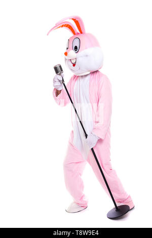 Taille de la vie ou costume de lapin lapin de Pâques chante en rétro microphone. Chanteur musicien drôle s'amuser avec microphone Elvis Banque D'Images