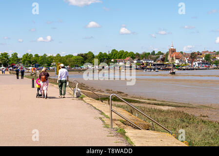 Les gens qui marchent sur la promenade à Maldon, Essex, UK, le long de la rivière Blackwater. La ville de Maldon en arrière-plan, l'église, barges à Thames Banque D'Images