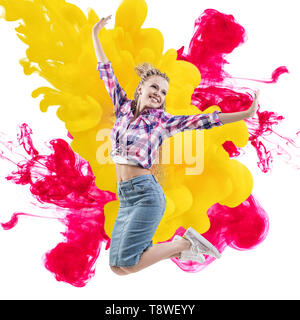 Happy woman sauts sur fond d'explosion des peintures. Banque D'Images