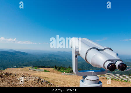 Jumelles électroniques fonctionnant avec des pièces pour les touristes sur une montagne paysage d'été Banque D'Images