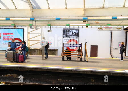 Les voyageurs en attente sur la plate-forme à la station Hammersmith, Londres, UK Banque D'Images