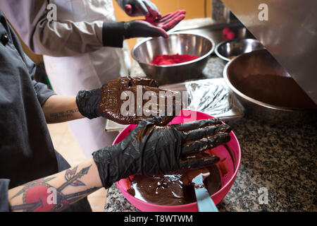 Chocolats cuisine thème truffe. Close-up part Young Caucasian woman and man cook avec tatouage et en uniforme se prépare, fait balltake ronde la douce Banque D'Images