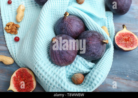 Figues mûres fraîches avec serviette sur table en bois couleur Banque D'Images