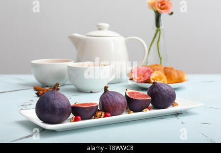 Plaque avec des figues mûres sur table lumineuse Banque D'Images