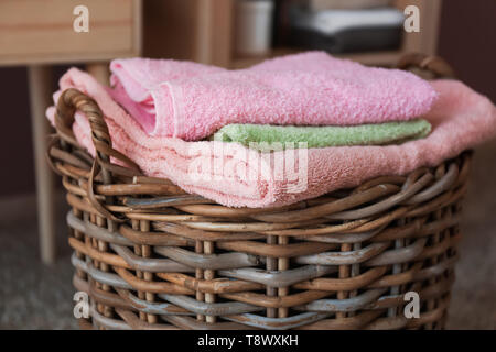 Panier en osier avec des serviettes pliées sur marbre Banque D'Images