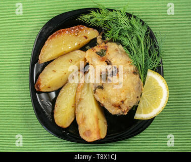 La nature morte avec du poisson frit et des pommes de terre au four sur un plat Banque D'Images