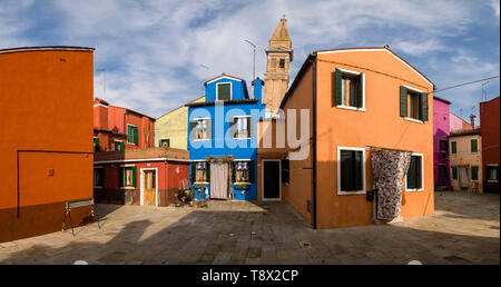 Maisons peintes de couleurs vives sur l'île de Burano, la tour de l'église St Martino, Chiesa di San Martino, dans la distance Banque D'Images