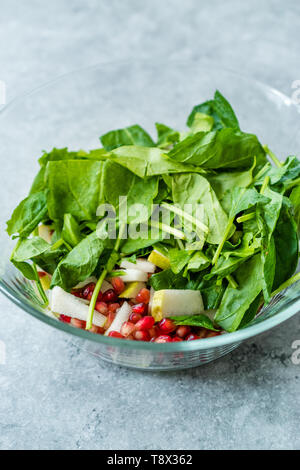 Pomegeranate et salade de poire dans un bol en verre prêt à faire. L'alimentation biologique. Banque D'Images