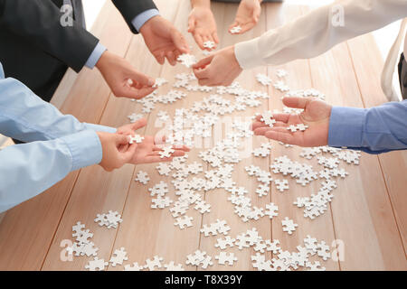 L'équipe d'assemblage puzzle on wooden table Banque D'Images