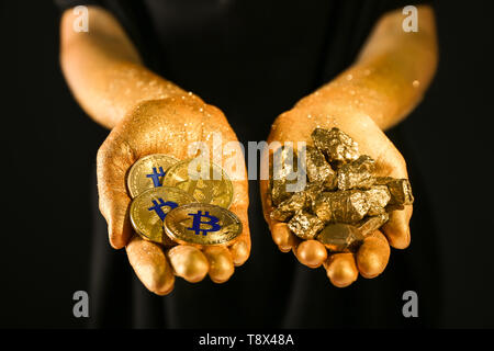 Femme avec des bitcoins et des pépites d'or sur fond noir, gros plan Banque D'Images