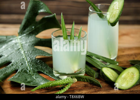 Verres de jus d'aloe vera frais avec le concombre sur planche de bois Banque D'Images