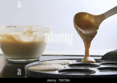 Faire des crêpes sur main de femme Verser la pâte. Banque D'Images