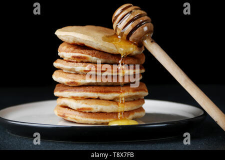 Pile de crêpes de verser le miel sur dark retour. decoration concept et le petit-déjeuner. Banque D'Images