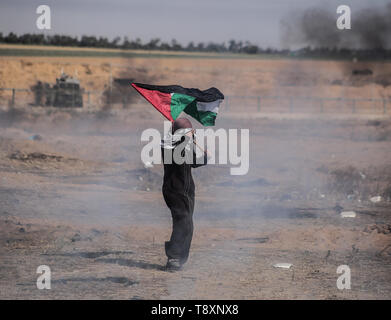 Gaza, Khan Younis, Palestine. 15 mai, 2019. Un manifestant palestinien vu tenant un drapeau pendant les affrontements se sont heurtés aux Palestiniens.Les forces israéliennes pendant les 71 ans, jour de la Nakba manifestation, appelant à la fin de l'blocus israélien de Gaza et le droit de retourner dans leurs foyers à la frontière entre Israël et Gaza, dans le sud de la bande de Gaza. Credit : Yousef Masoud SOPA/Images/ZUMA/Alamy Fil Live News Banque D'Images