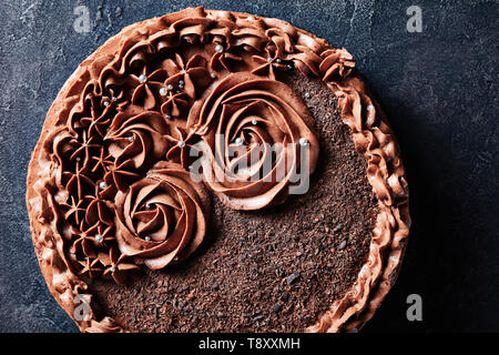 Gâteau de meringue au chocolat maison garnie de crème au beurre au chocolat roses et argent, dragee comestibles vue horizontale à partir de ci-dessus, mise à plat, copy space Banque D'Images